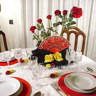 table setting idea for a Spanish dinner party. The centerpiece is made with a fan, mantilla and roses