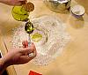 adding olive oil to flour
